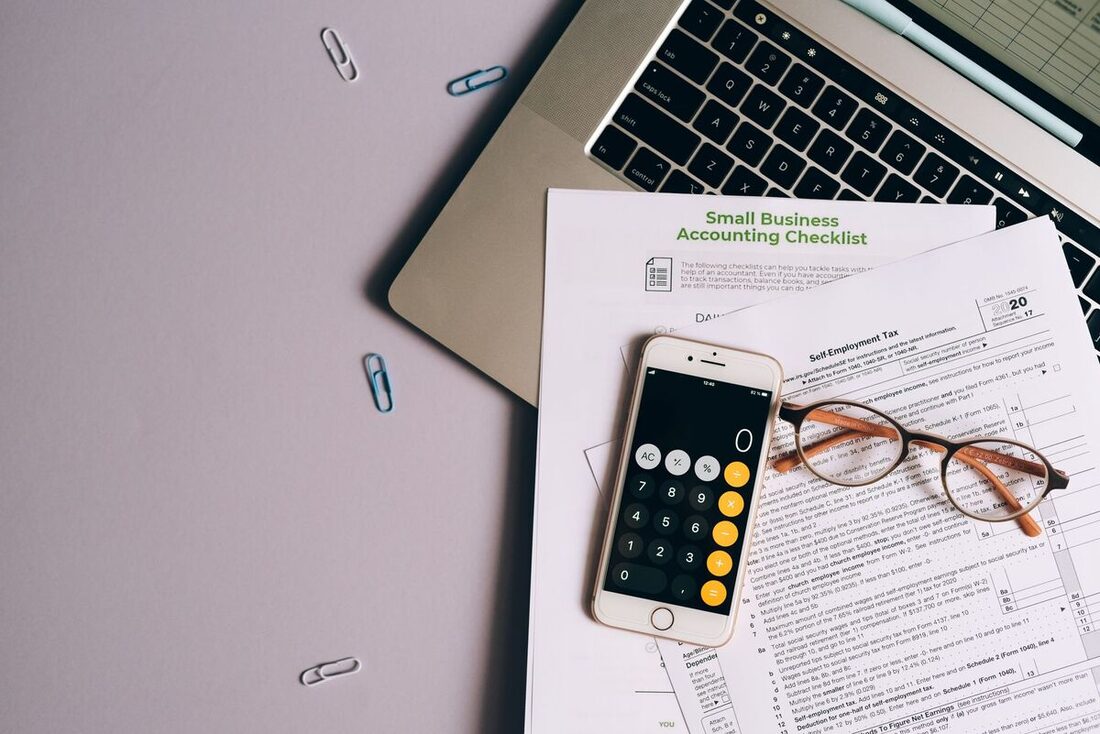 Small-business accounting checklist with calculator and laptop