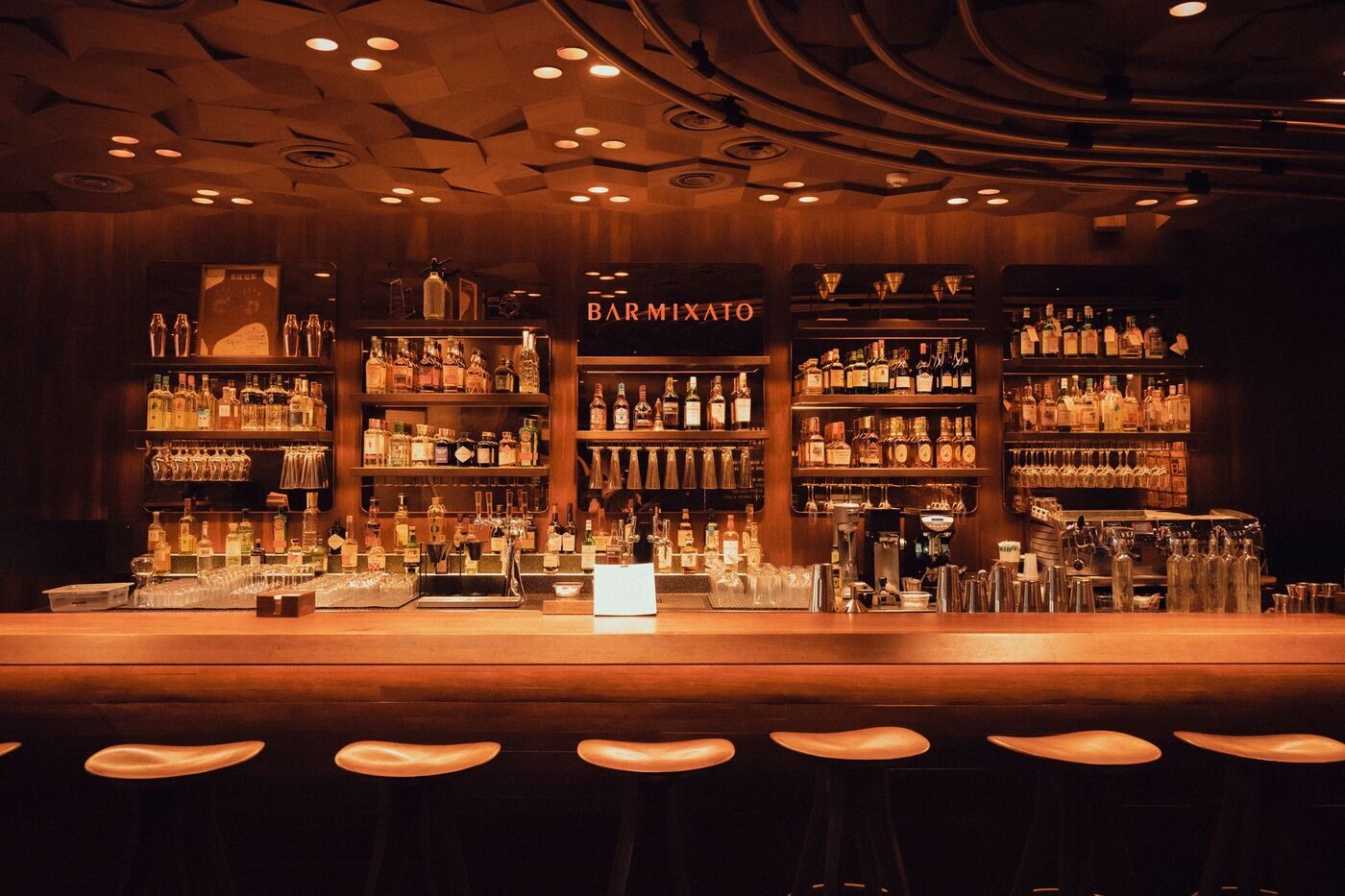 Warm-lit back bar with bottle shelves in a Nashville lounge