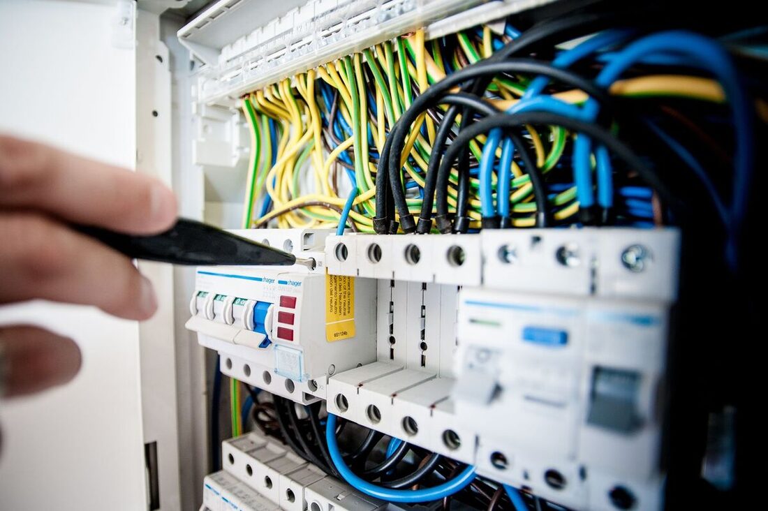 Electrician servicing breakers and wiring