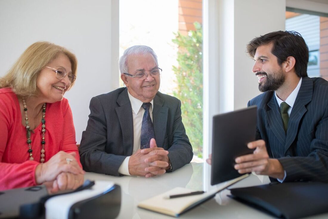 Advisor showing a retirement plan on a tablet to an older couple