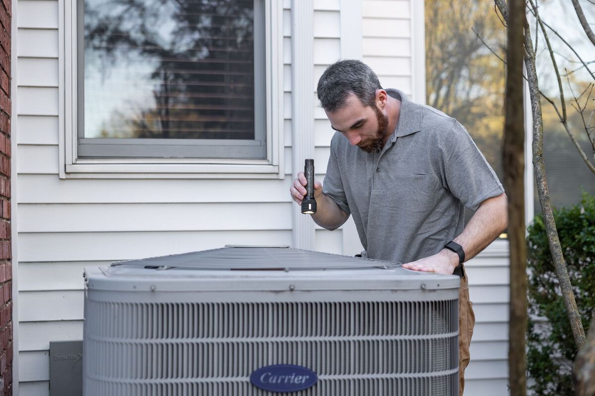 HVAC technician inspecting a residential AC condenser in Nashville