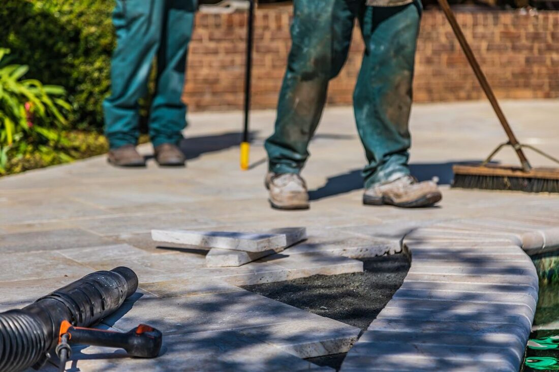 Crew installing natural stone pavers for a patio