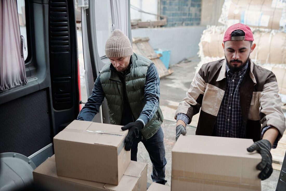 Workers loading boxes into a delivery van