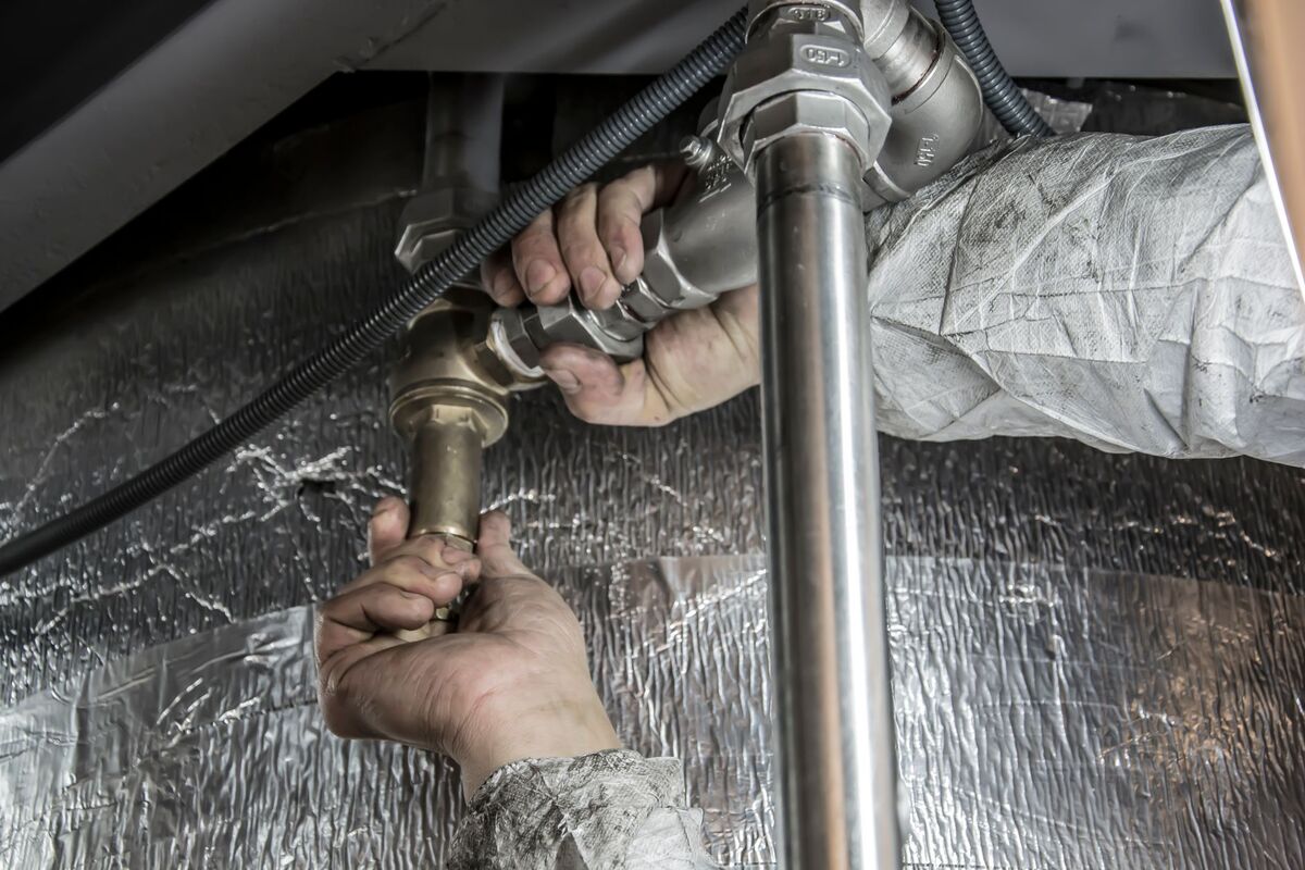 Plumber repairing pipework under a sink in a Nashville home